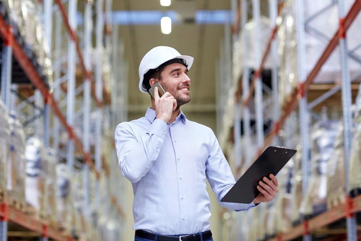 A man in a hard hat talking on the phone.