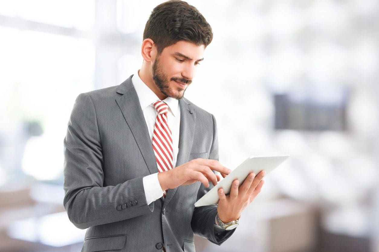A man in a suit and tie using his tablet.
